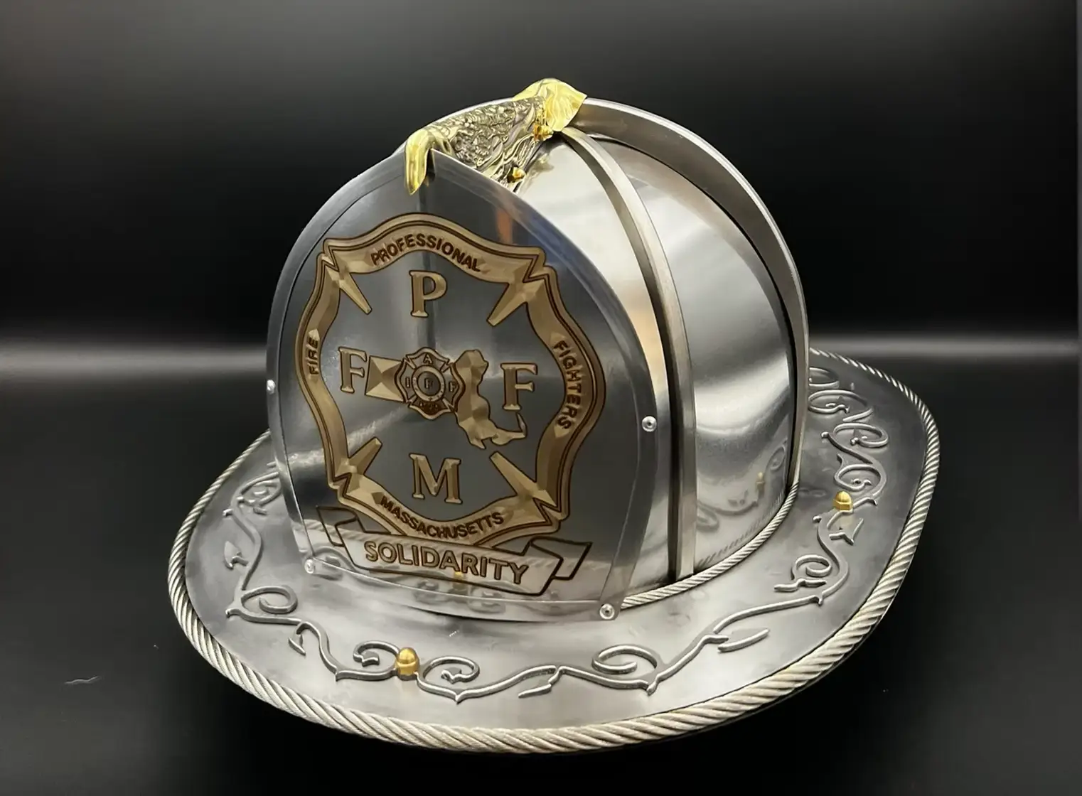 Custom steel firefighter helmet engraved with the PFFM Massachusetts Solidarity shield and topped with a brass eagle
