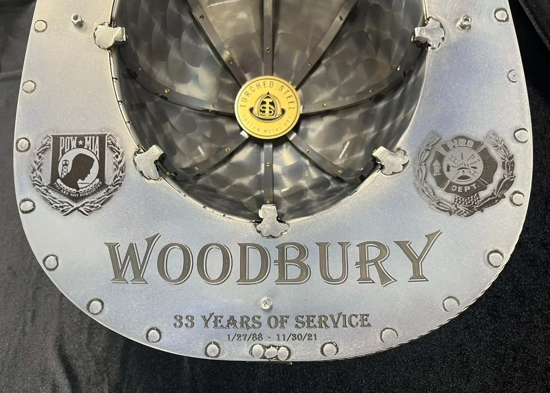 Close-up engraving detail on a custom steel firefighter helmet by Torched Steel